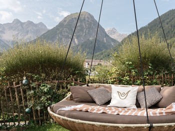 Lieblingsplatz mit Bergblick Eine gemütliche Hängeliege im Garten lädt zum Entspannen und Verweilen ein. Im Hintergrund eröffnet sich ein beeindruckender Blick auf die Bergwelt des Brandnertals.