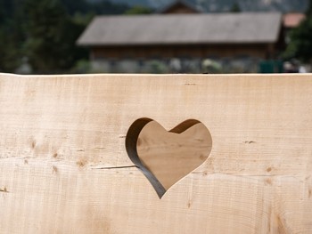 Herzlichkeit im Brandnertal Ein helles Holzbrett mit einem ausgestanzten Herz als liebevolles Detail im Brandnertal.