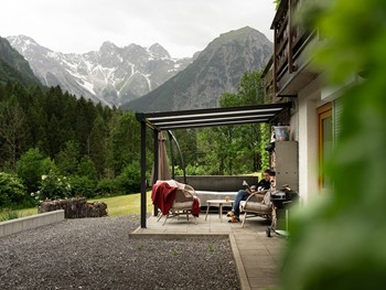 Wohnen mit Bergblick im Brandnertal Gemütliche Terrasse einer Mitarbeiterunterkunft mit Blick auf die umliegende Berglandschaft. Eine Mitarbeiterin nutzt den Außenbereich zum Entspannen.