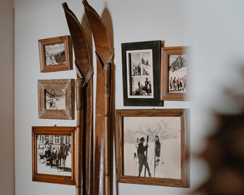 Traditionelle Atmosphäre mit Geschichte Gerahmte Schwarzweißfotografien und alte Skier erzählen von vergangenen Zeiten in den Bergen.